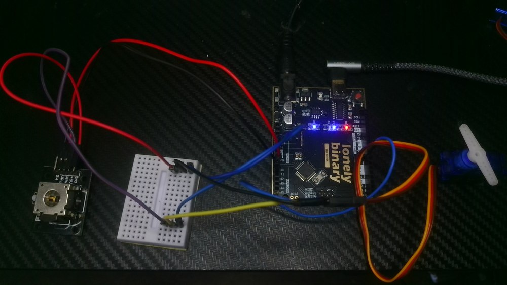 George’s joystick, Arduino-compatible controller, mini breadboard, and SG90 micro servo on the bench.
