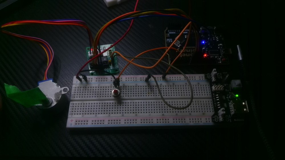 George’s breadboard with a push button, Uno-compatible controller, ULN2003 driver board, and small geared stepper motor.